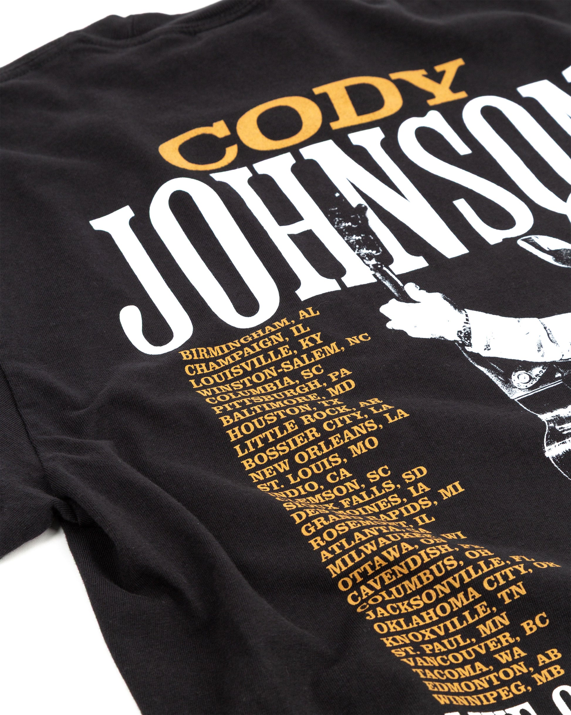 Black t-shirt with 'Cody Johnson' and city names printed on it