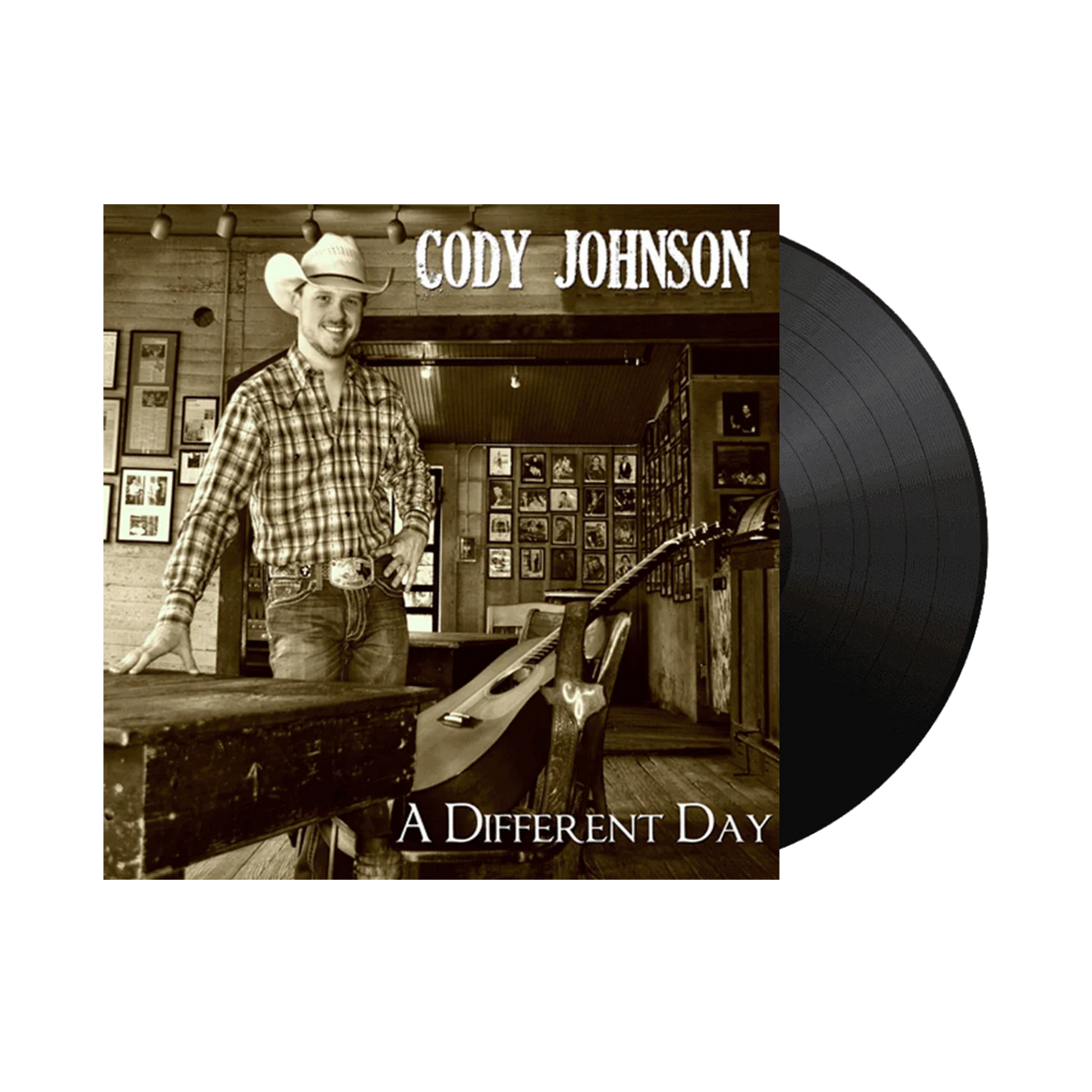 Vinyl record with a cover featuring a man in a cowboy hat and plaid shirt, titled 'A Different Day' by Cody Johnson.
