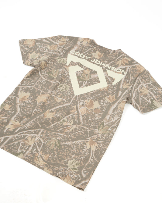 A short-sleeve crewneck t-shirt featuring a brown and beige woodland camouflage pattern with a large COJO Bull Logo and 'Cody Johnson' text across the back