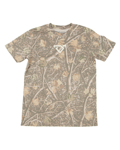 A short-sleeve crewneck t-shirt featuring an all-over camouflage pattern of branches and leaves in shades of brown, beige, and gray, with a small cream COJO bull logo on the center chest.