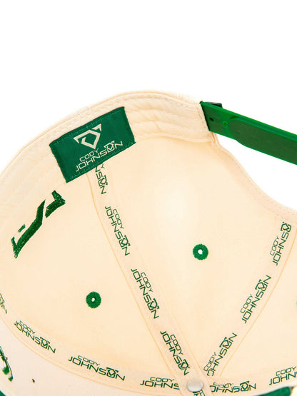 Beige cap with green branding on a white background